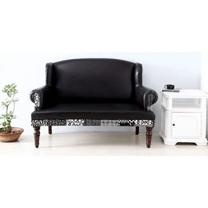 A black Maharani 2 seater sofa with rexine and velvet touch fabric, featuring round front legs with walnut color.