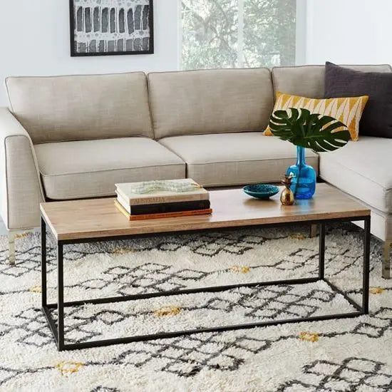 A rectangular coffee table with a mango wood top and black metal base. 