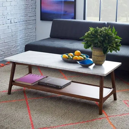 A rectangular coffee table with a white marble top and brown sheesham wood base. 