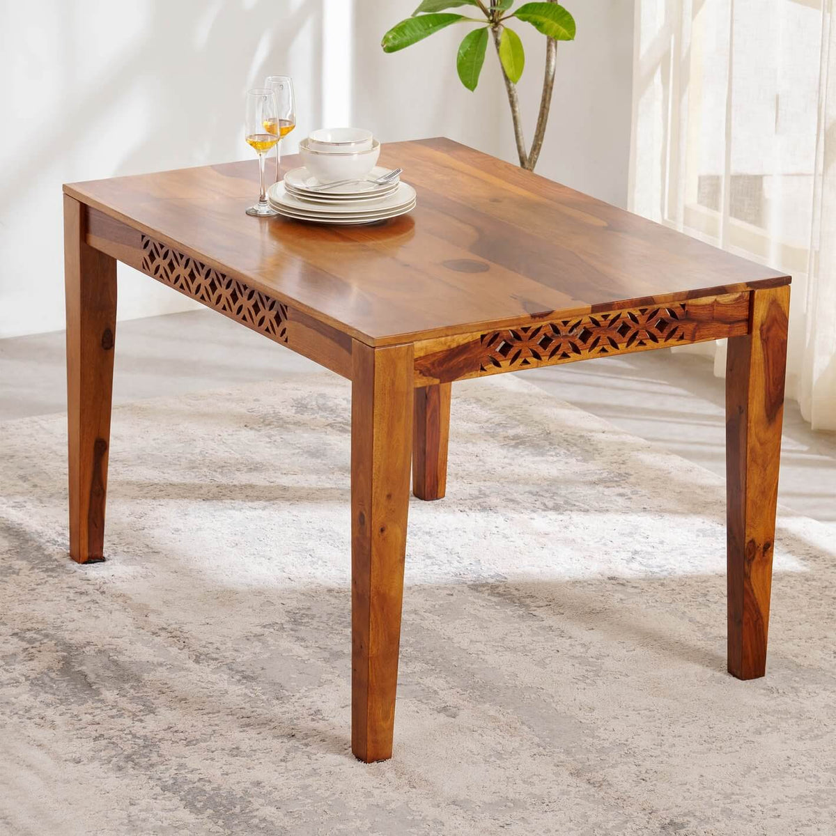 A rectangular wooden dining table with carved geometric.