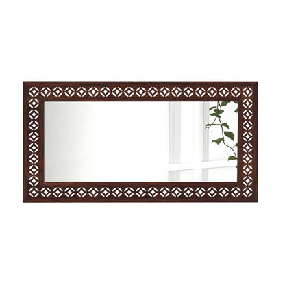 A rectangular wall mirror with an ornate dark brown wooden frame featuring a repeating geometric cutout pattern.