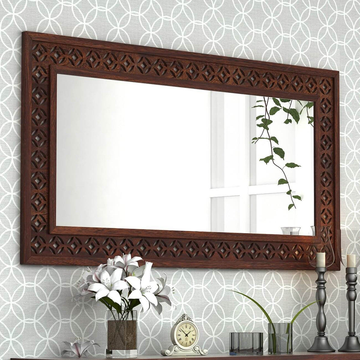 A large rectangular wall mirror with an ornate dark brown carved wooden frame.