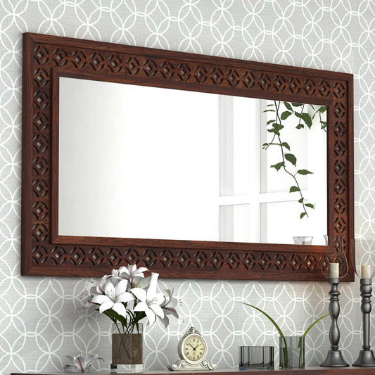 A large rectangular wall mirror with an ornate dark brown carved wooden frame.