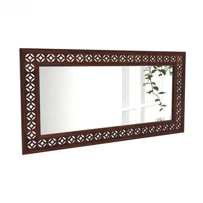 A rectangular wall mirror with an ornate dark brown wooden frame featuring a repeating diamond lattice cutout pattern.