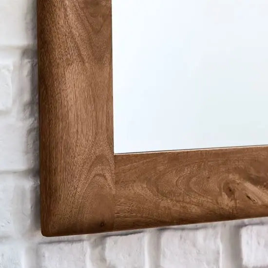 A medium-sized rectangle mirror frame made of mango wood, mounted for wall.