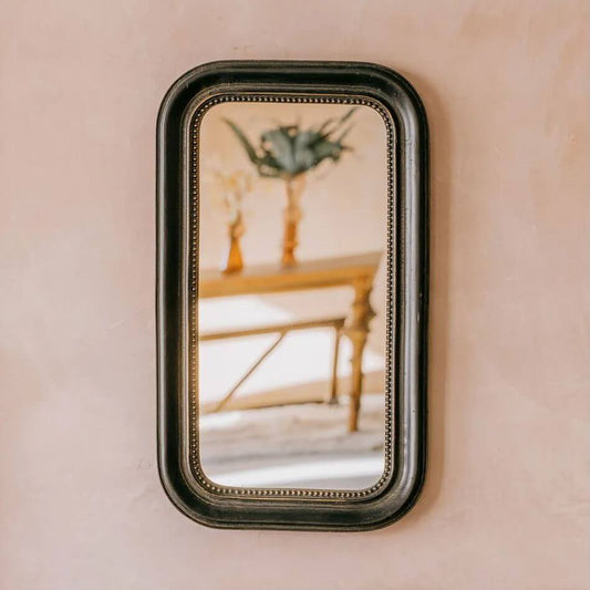 A rectangular round edge wall mirror with a dark finish, Metal beeded frame.