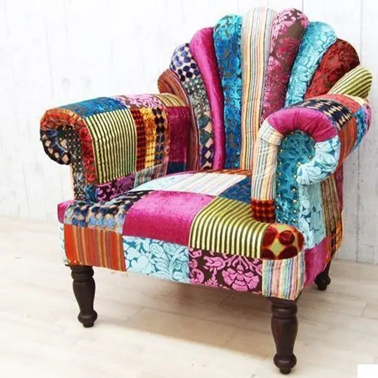 A multicolored upholstered fabric peacock wing chair with a vibrant backrest and comfortable armrest.
