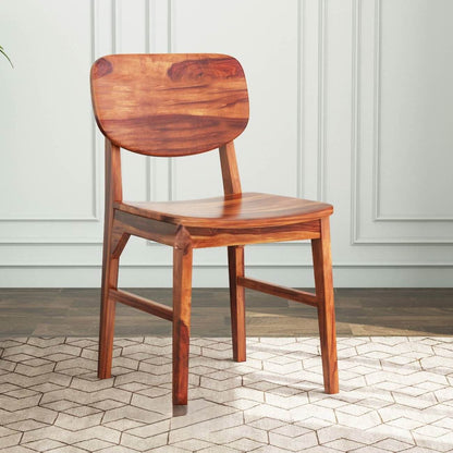 A warm reddish-brown wooden dining chair with a curved backrest and seat.