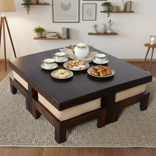 A low-profile square coffee table with dark wood finish and beige cushioned edges.