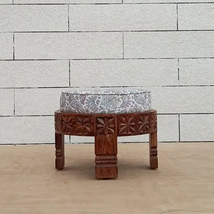 Wooden hand craved round footstool in natural finish. 