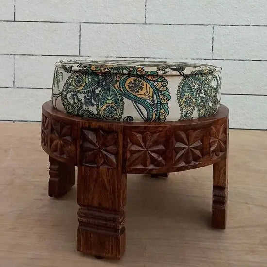 A hand-carved wooden footstool with a round shape.