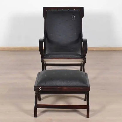 A black artificial leather upholstered Rambo Relax chair with foot stool.