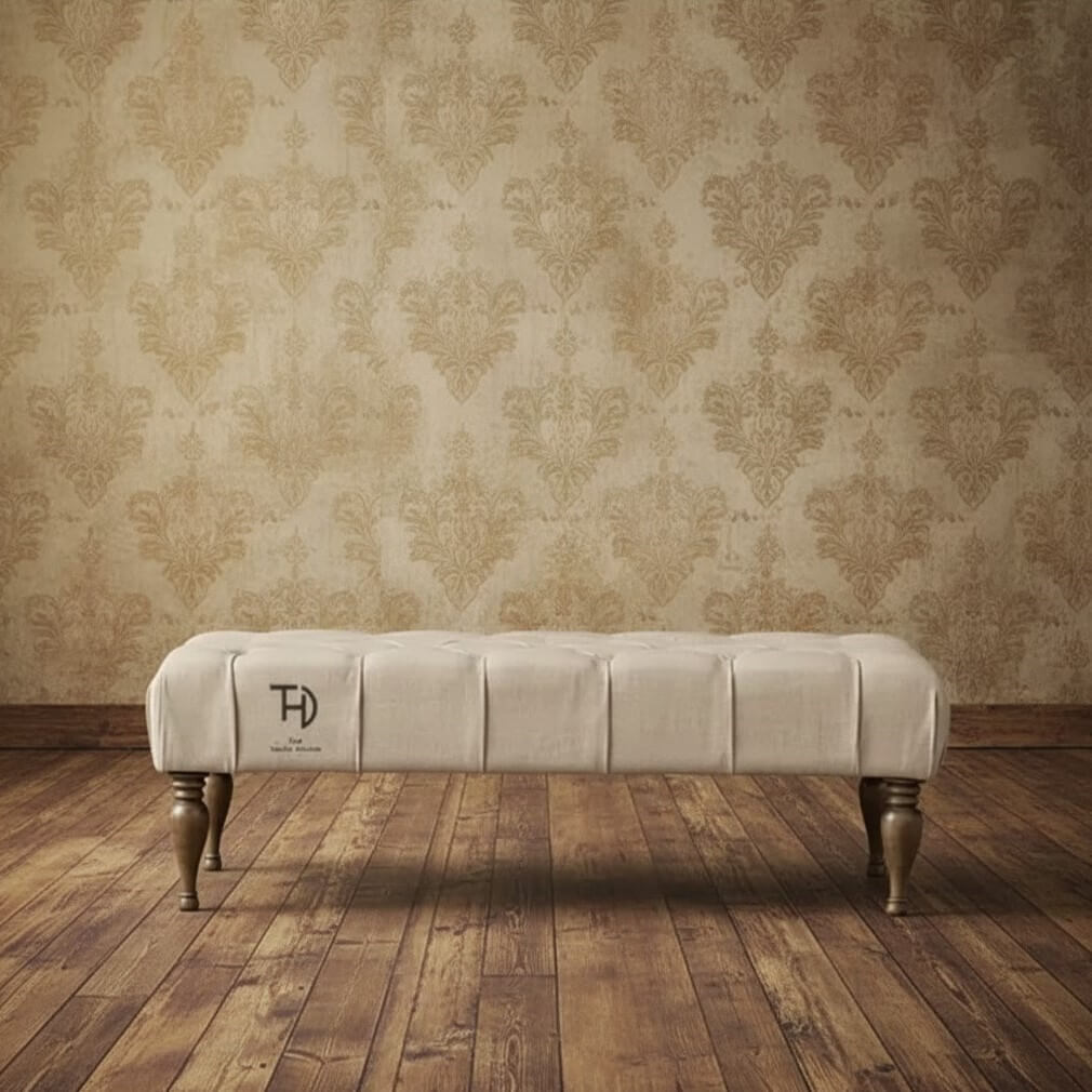 An upholstered cream fabric coffee table with tufted design and bottle-shaped turned wooden legs.