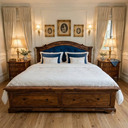 A classic wooden bed frame with a dark blue upholstered headboard.