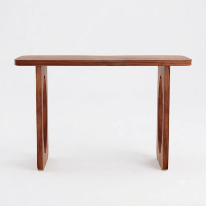 A mid-century modern wooden console table with a warm reddish-brown finish, featuring a rectangular top and two sculptural legs with circular cutouts.