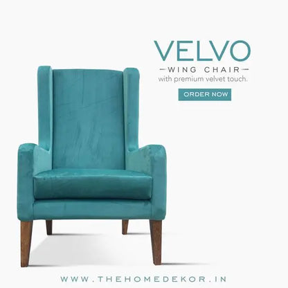 A luxurious olive green velvet wing chair with a sturdy wooden structure, featuring a high back and winged armrests.