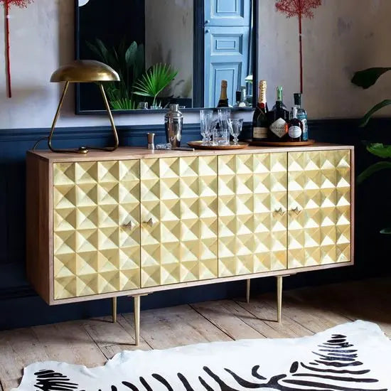 The shutters are carved out and coated in a gold finish to add a three-dimensional effect to the sideboard.