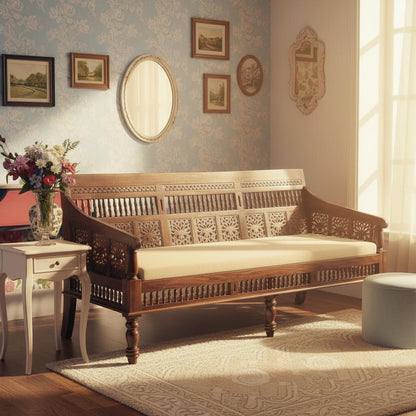 A three-seater vintage sofa with a sturdy Sheesham wood frame, hand-carved details, and a cushioned seat in a warm honey color.
