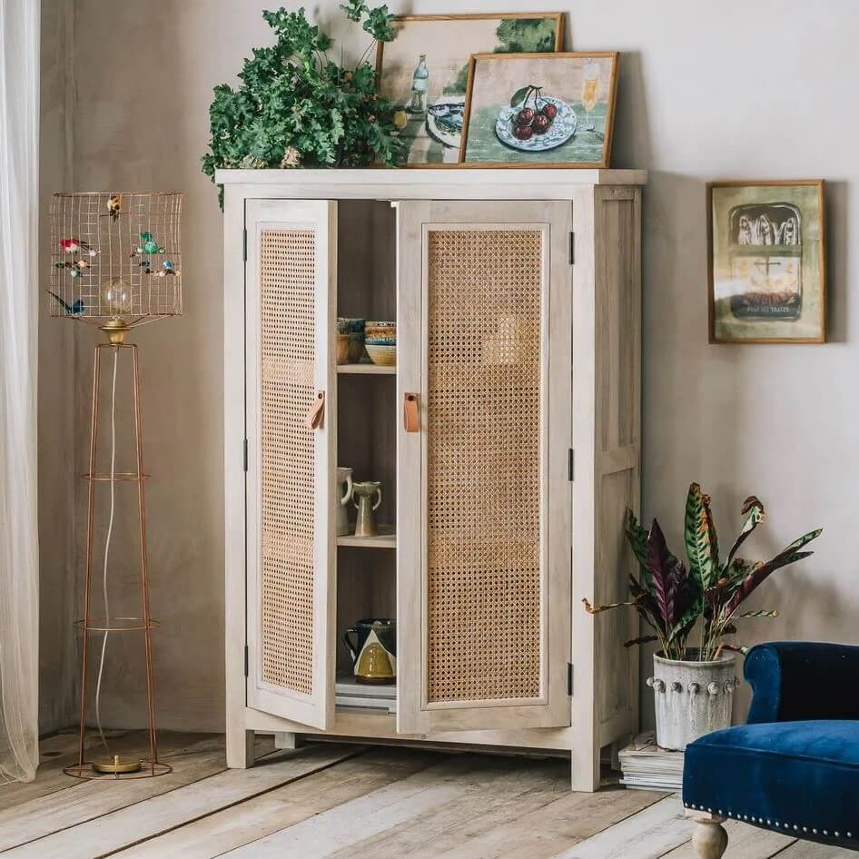 A tall, light beige wooden cabinet with two cane-embossed doors made in Real solid mango wood and natural rattan.