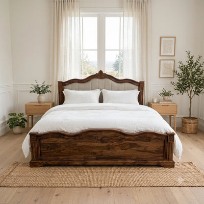 A dark brown wooden bed frame with a carved headboard and footboard.